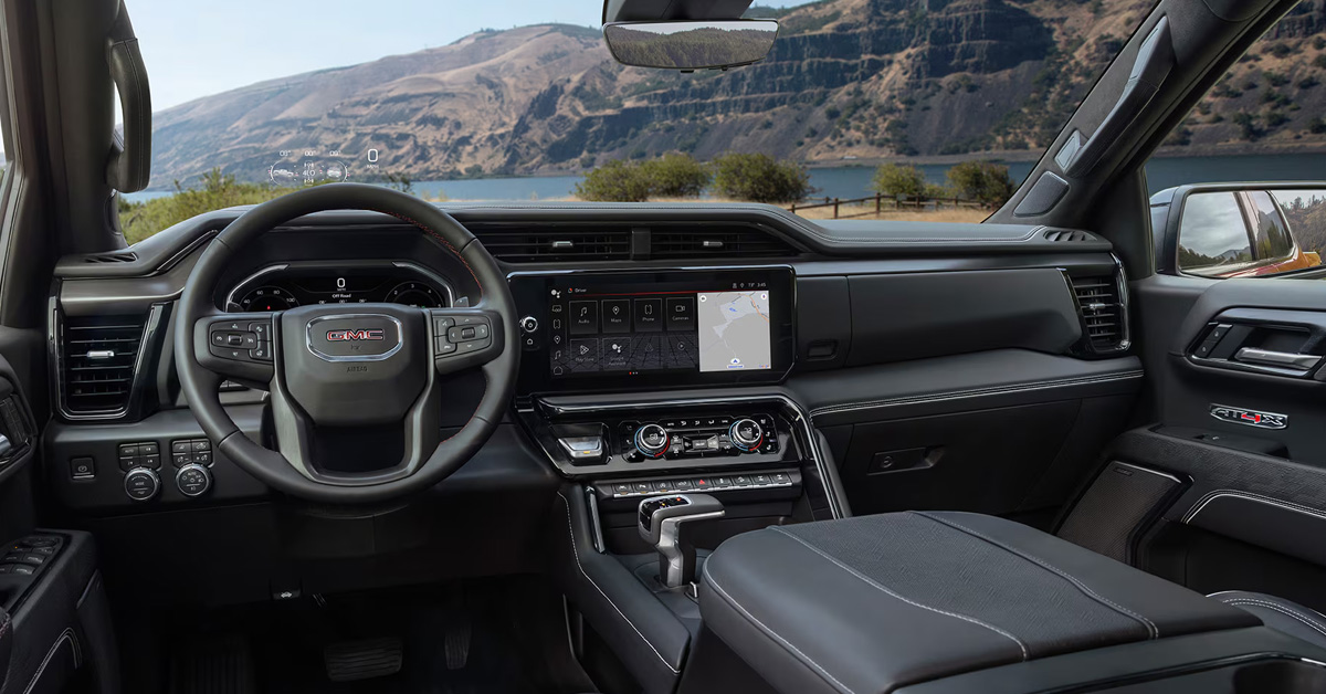 The interior of a 2026 GMC Sierra 1500 showing the steering wheel and infotainment system